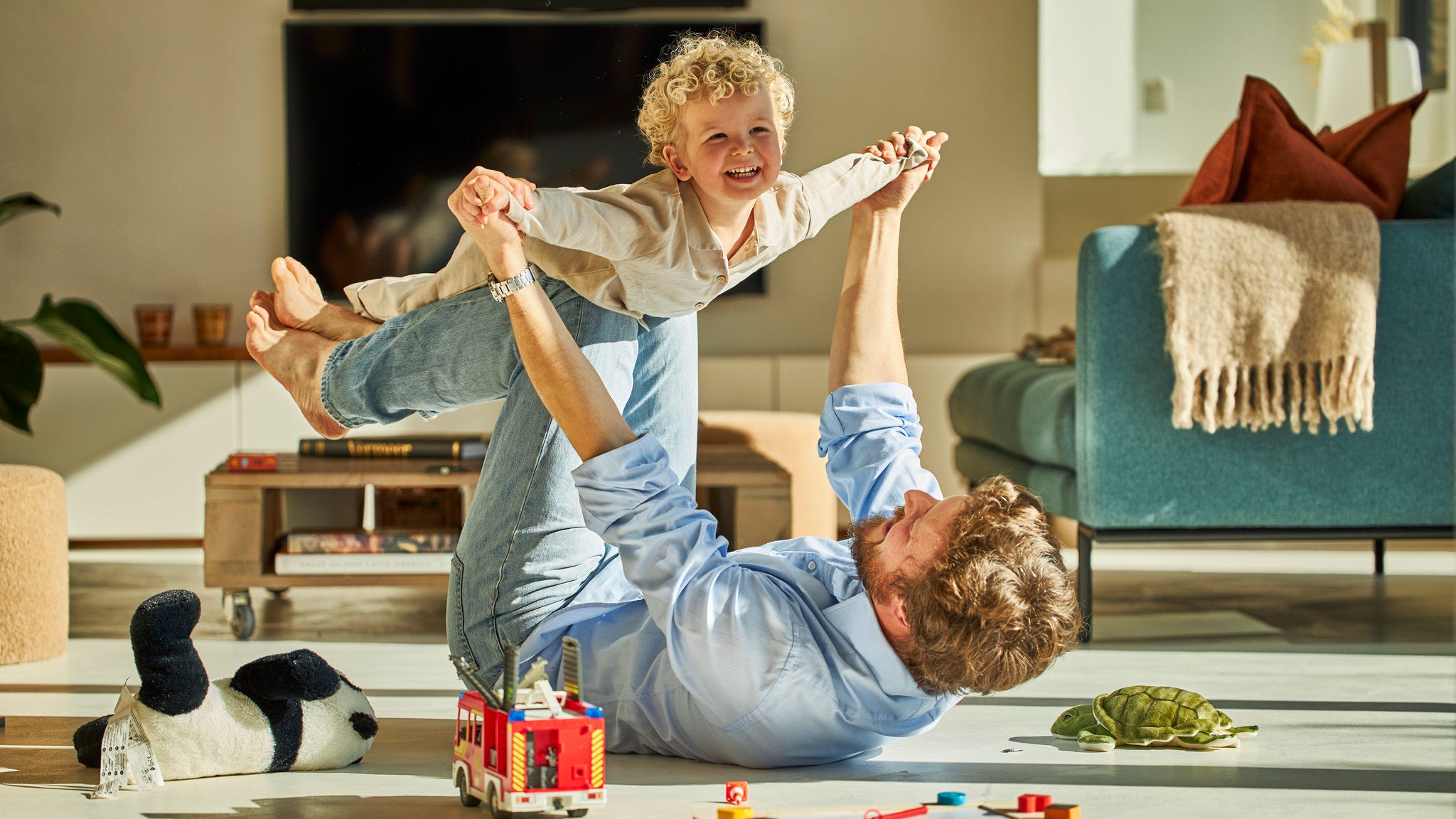 Otec a jeho dítě si spolu spokojeně hrají a užívají si chladného vzduchu