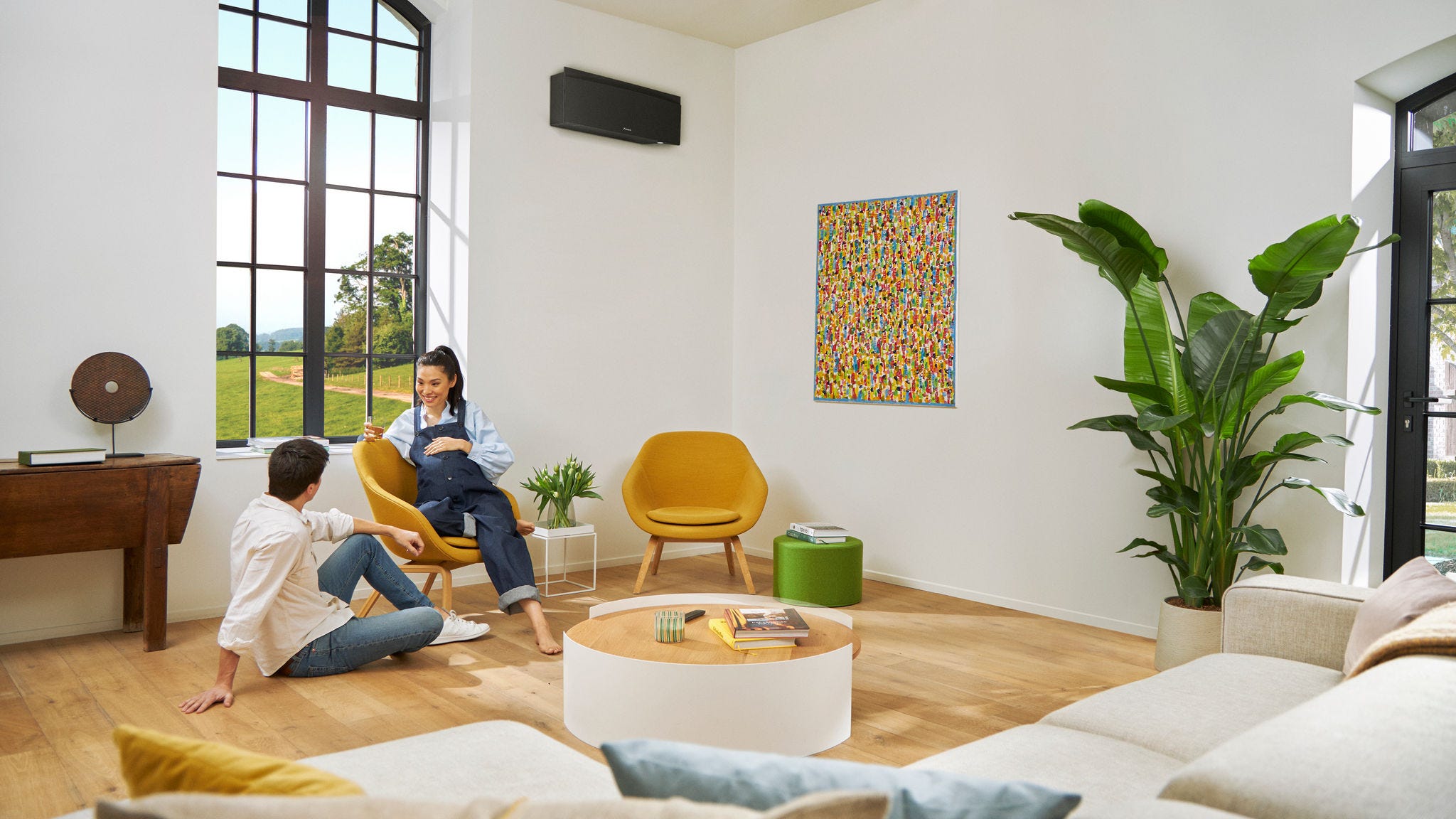 Pár čekající miminko si nezávazně povídá, přičemž žena sedí na židli