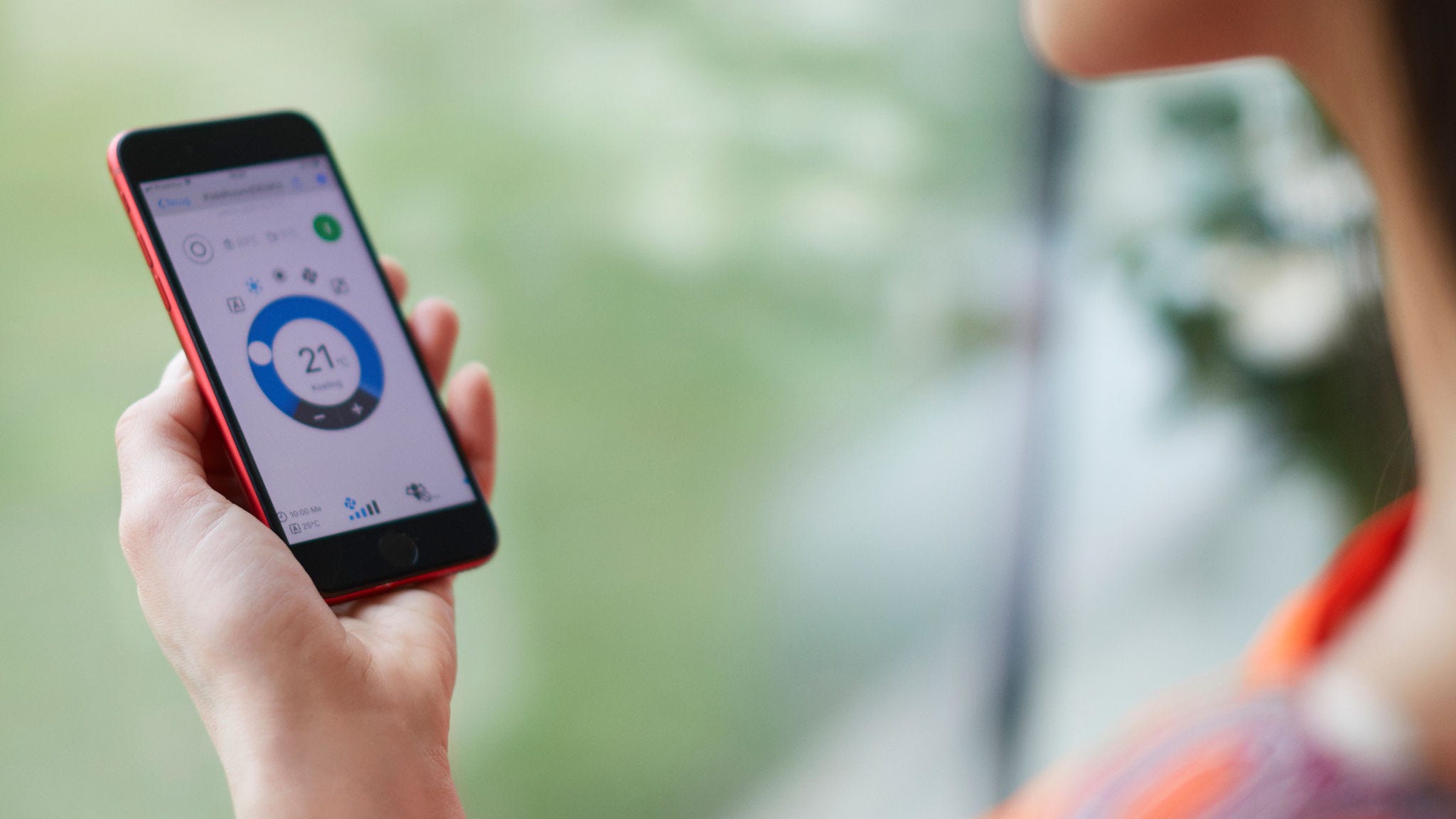 Žena používá aplikaci k ovládání svého vytápění